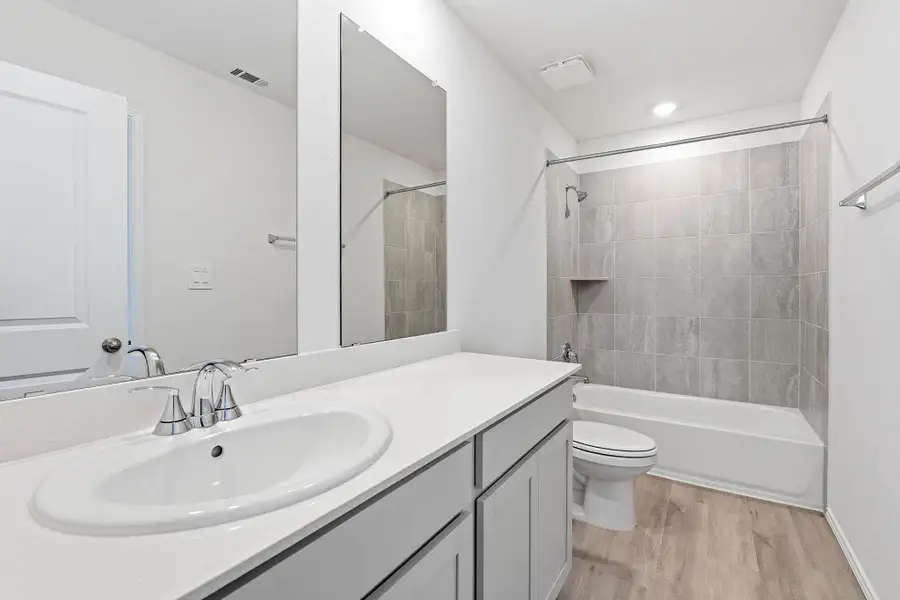 Bathroom featuring a single vanity with an oval sink, polished chrome faucet, and white countertop Bathroom featuring a single vanity with an oval sink, polished chrome faucet, and white countertop