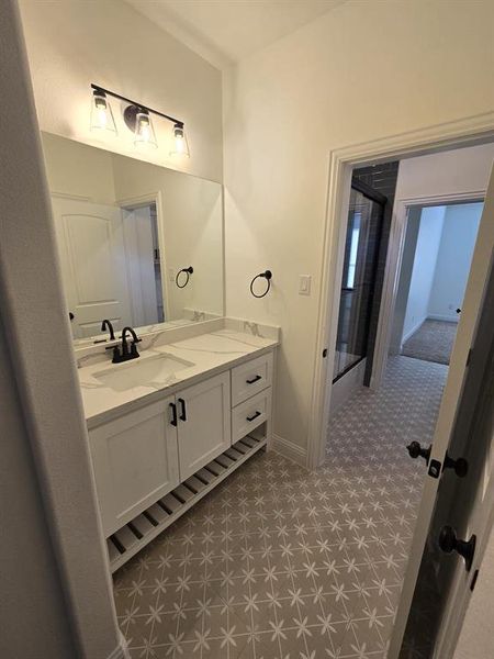 Bathroom with a shower with shower door, vanity, and tile patterned floors