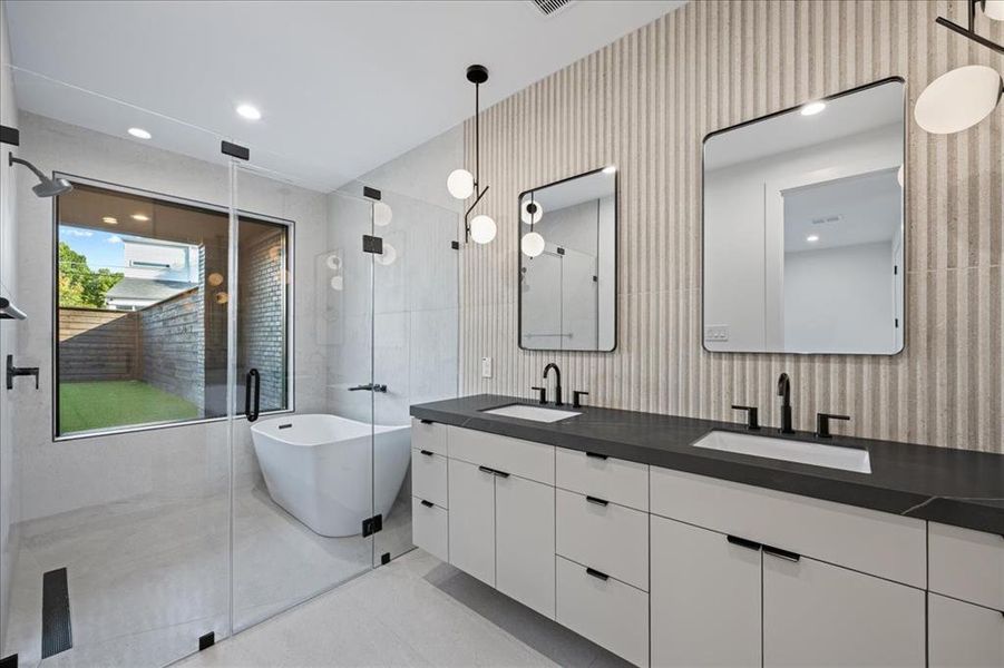 Full bath with a freestanding tub, double vanity, a stall rain shower, light tile patterned floors, and recessed lighting Full bath with a freestanding tub, double vanity, a stall rain shower, light tile patterned floors, and recessed lighting