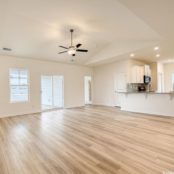 Unfurnished living room featuring light wood-type flooring, a ceiling fan, recessed lighting, and vaulted ceiling