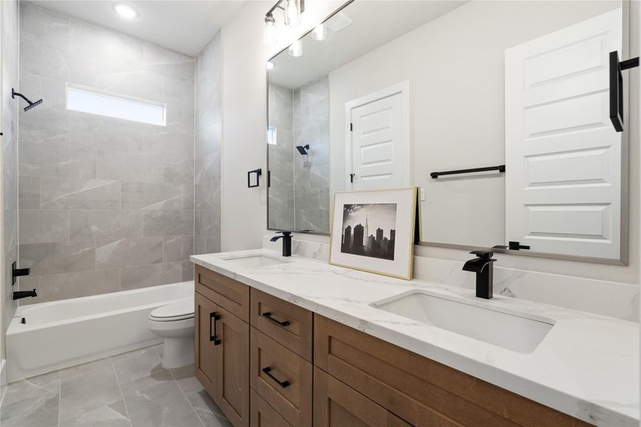 Dual sinks add everyday convenience, while full-height tile work elevates the space with a clean, modern finish. Dual sinks add everyday convenience, while full-height tile work elevates the space with a clean, modern finish.