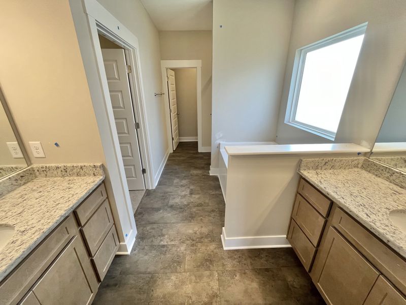 Nice large bathroom with separate vanities, garden tub, large privacy window, tile shower and private toilet area Nice large bathroom with separate vanities, garden tub, large privacy window, tile shower and private toilet area