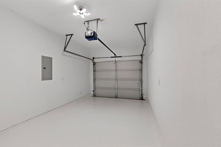 Garage featuring electric panel and a garage door opener Garage featuring electric panel and a garage door opener