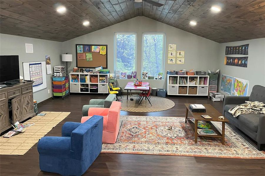Barndominium school room with dark wood-style flooring, recessed lighting, lofted ceiling, ceiling fan, and wooden ceiling Barndominium school room with dark wood-style flooring, recessed lighting, lofted ceiling, ceiling fan, and wooden ceiling