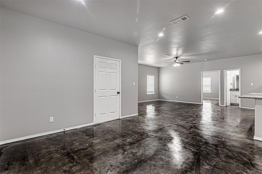 Unfurnished living room featuring dark tile patterned flooring and ceiling fan