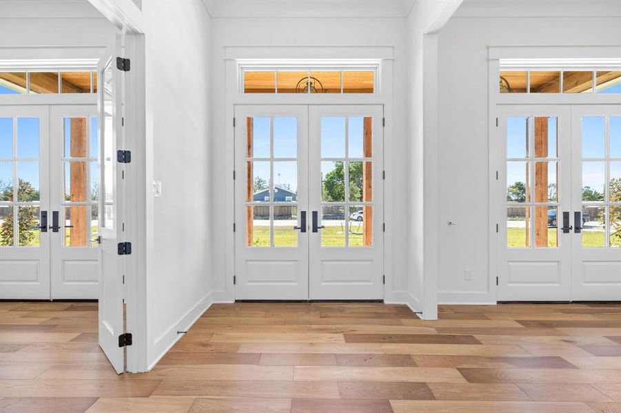 Foyer entrance with plenty of natural light, french doors, and light hardwood / wood-style flooring