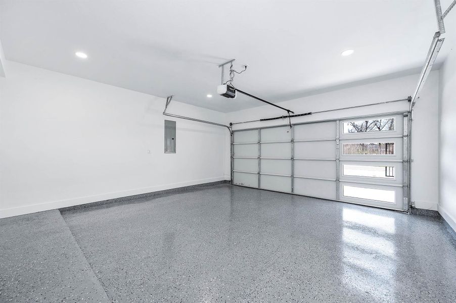 Spacious two-car garage featuring epoxy flooring and a clean, finished interior.