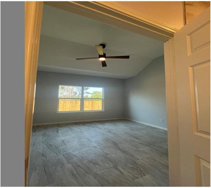 Spare room featuring ceiling fan and vaulted ceiling