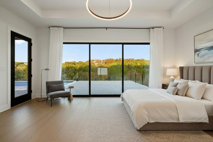 Expansive glass sliding doors open to an outdoor terrace with a dark metal railing