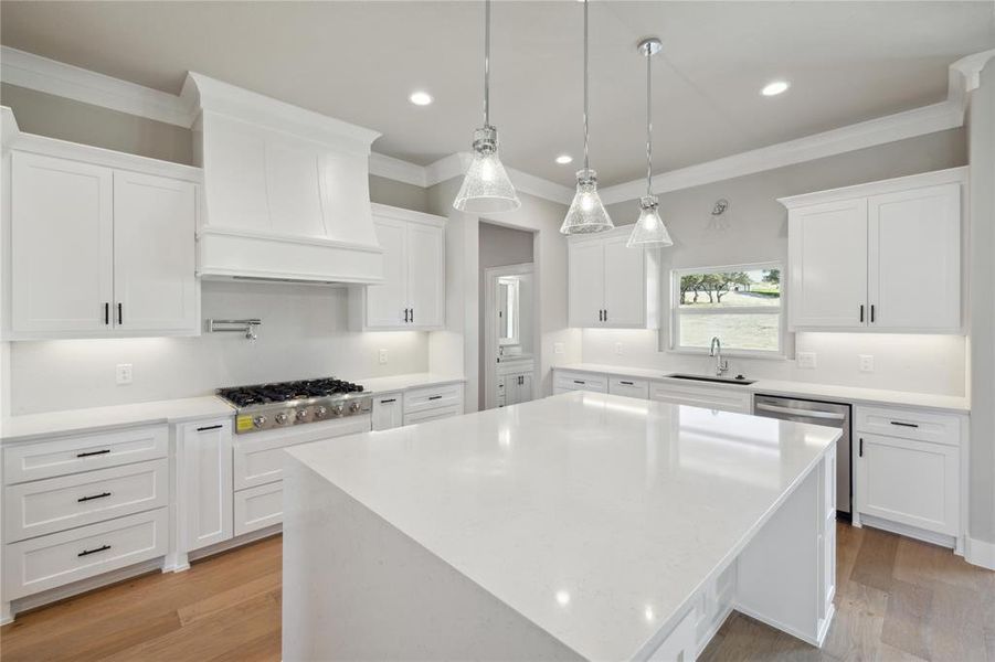 Kitchen with white cabinets, appliances with stainless steel finishes, and a center island