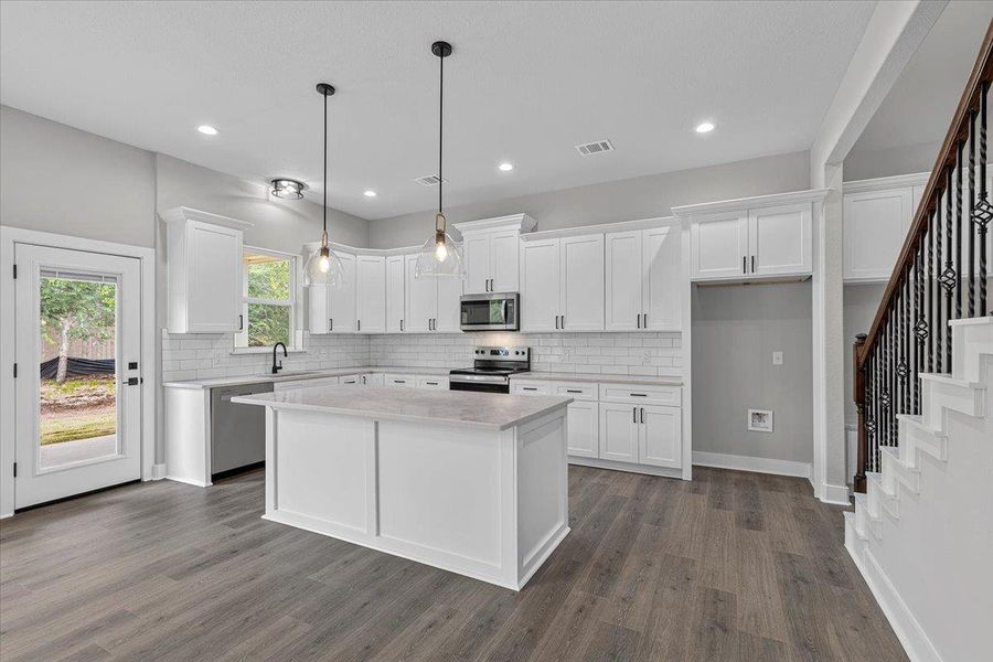 A well-lit kitchen with sleek appliances and ample counter space awaits culinary adventures. A well-lit kitchen with sleek appliances and ample counter space awaits culinary adventures.
