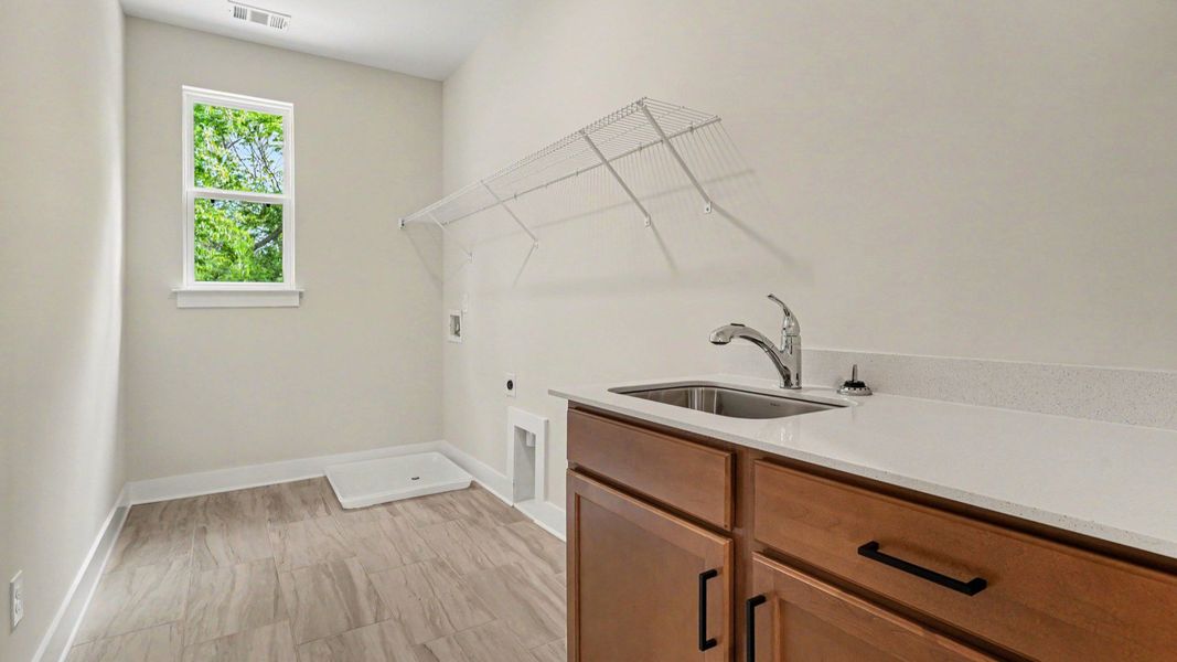 Spacious dedicated laundry room with window, sink, and ventilated shelf Spacious dedicated laundry room with window, sink, and ventilated shelf