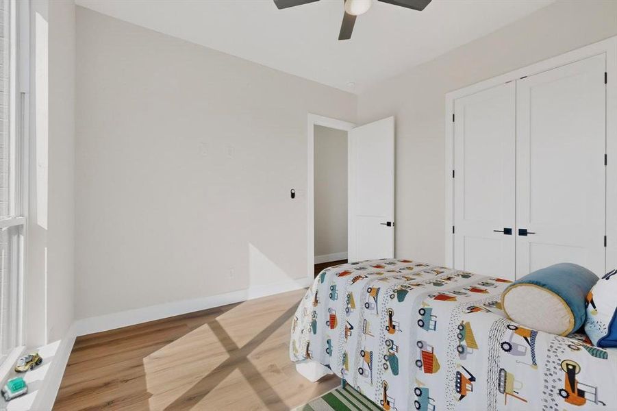 Bedroom with light wood-style floors, a ceiling fan, and a closet