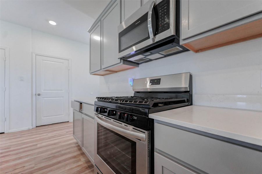 Stainless steel gas range and built-in microwave make cooking easy. Soft-close cabinets and sleek finishes give this Katy kitchen a modern feel. Stainless steel gas range and built-in microwave make cooking easy. Soft-close cabinets and sleek finishes give this Katy kitchen a modern feel.