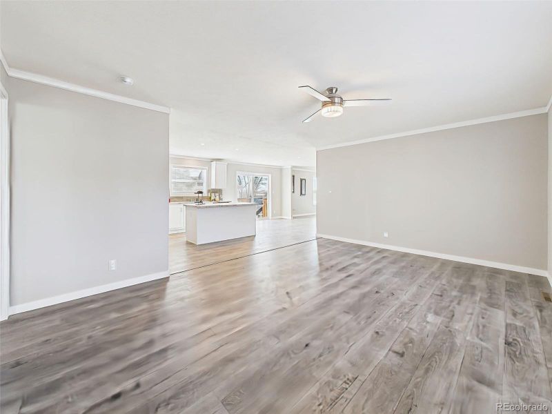 Back Family Room (Unstaged) – A well-lit and generously sized room, perfect for relaxing or entertaining, with double windows and access to the home's private quarters.