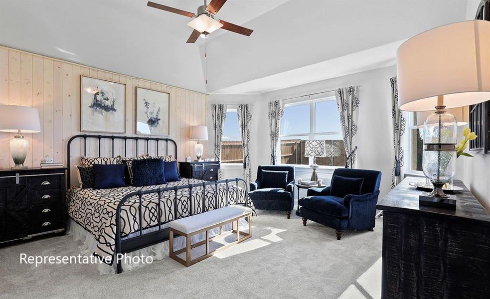 Carpeted bedroom featuring wooden walls, ceiling fan, and high vaulted ceiling