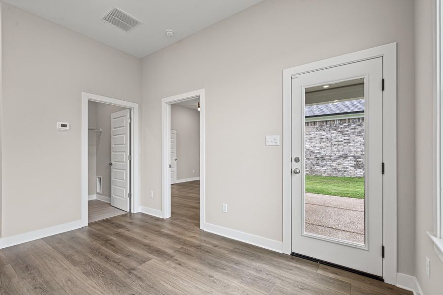Doorway with wood finished floors and baseboards