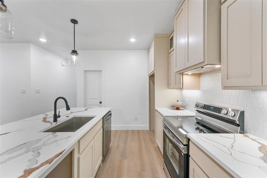 Modern kitchen featuring light wood-finish flooring and a white color palette Modern kitchen featuring light wood-finish flooring and a white color palette