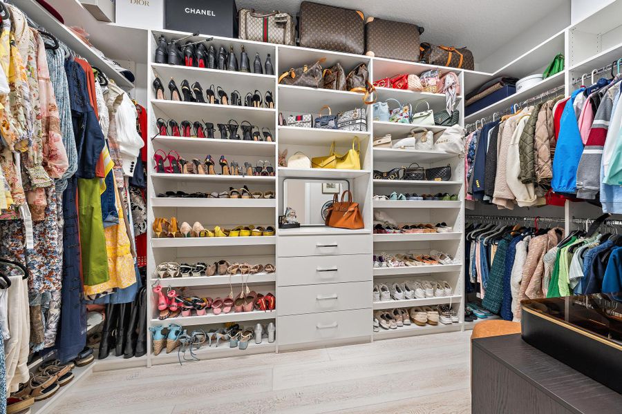 Custom closet built-ins with shelving, drawers, and chrome hardware.