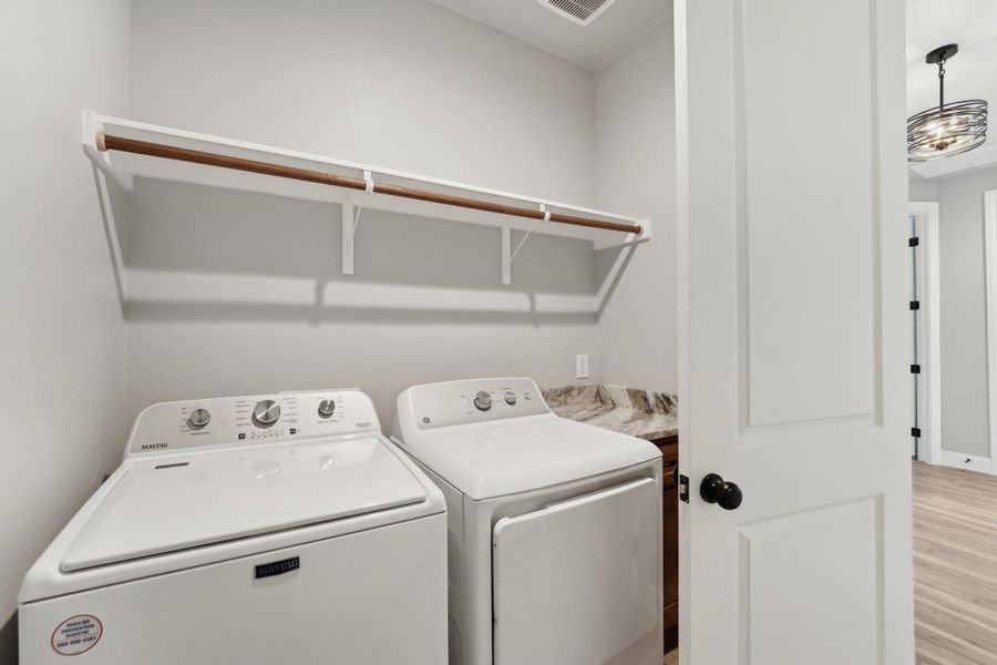 Laundry area featuring light wood finished floors, laundry area, and separate washer and dryer