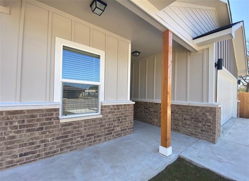 A welcoming front facade showcases a harmonious blend of brick and vertical siding, complemented by a covered porch with a natural wood post. A welcoming front facade showcases a harmonious blend of brick and vertical siding, complemented by a covered porch with a natural wood post.