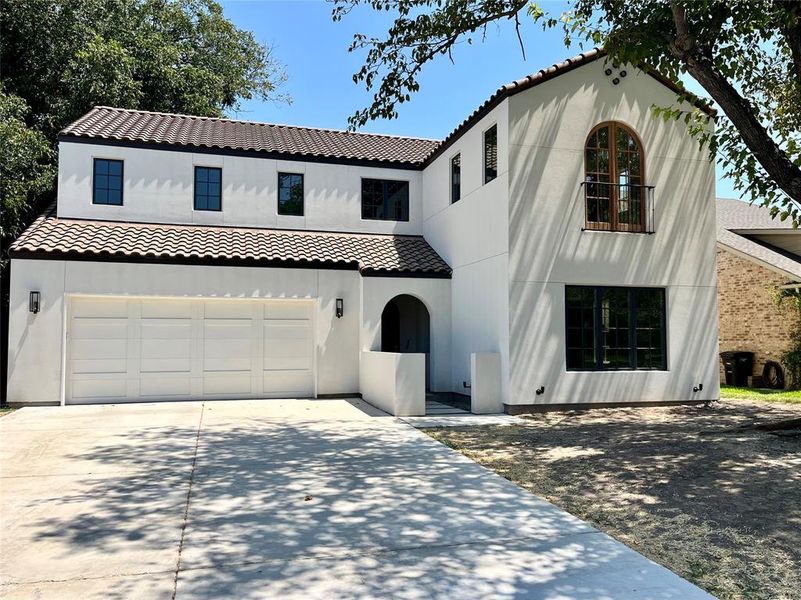 Mediterranean / spanish-style home with a garage