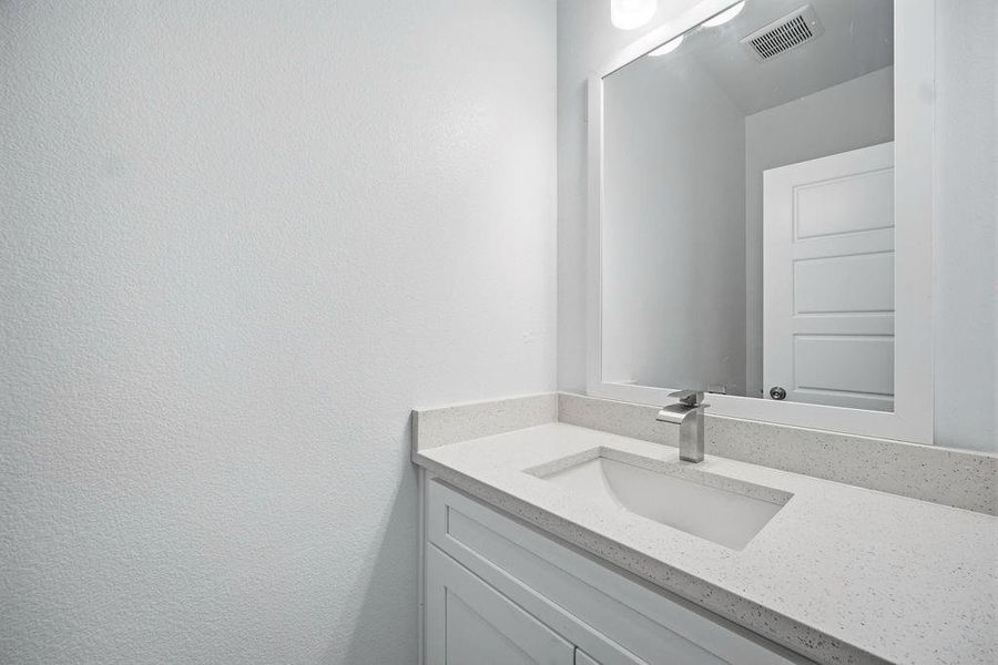 Contemporary bathroom vanity featuring a light-toned countertop with an integrated rectangular sink Contemporary bathroom vanity featuring a light-toned countertop with an integrated rectangular sink