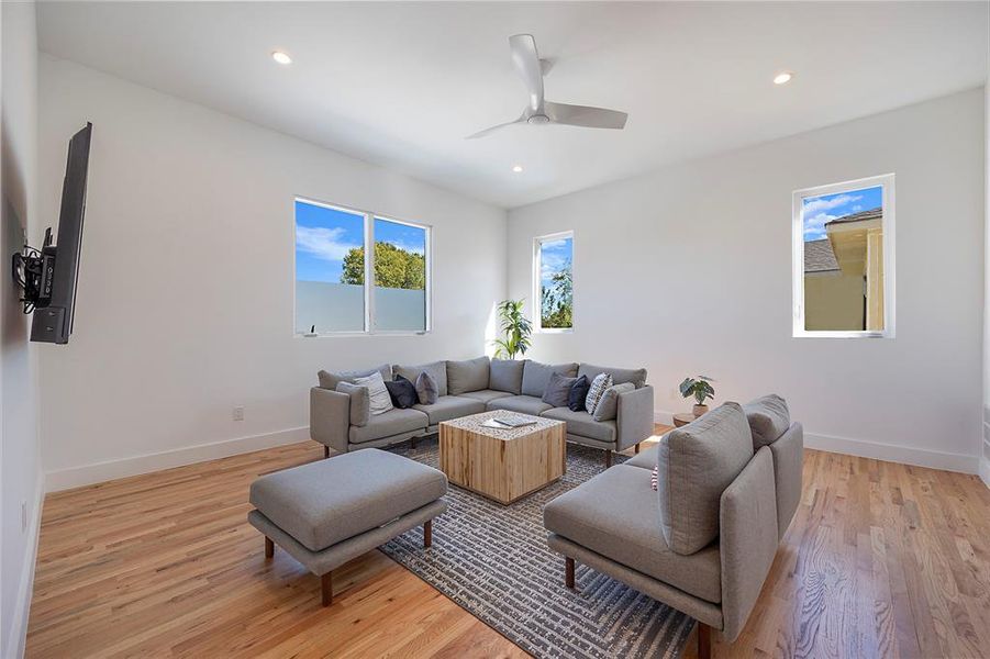 Living room with light hardwood / wood-style flooring and ceiling fan