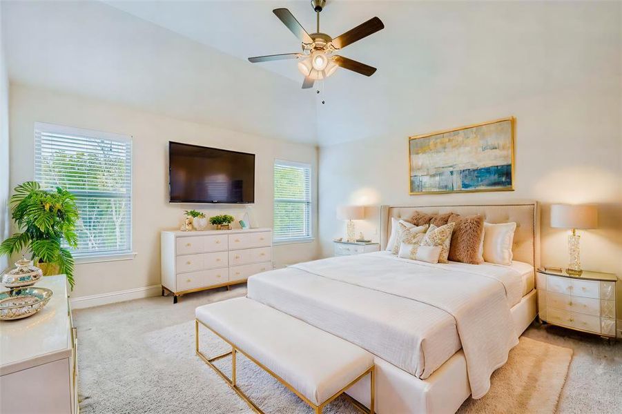 Carpeted bedroom with ceiling fan and a towering ceiling