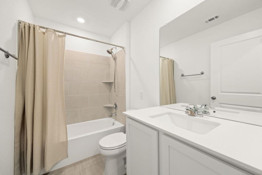 A well-appointed bath features a tiled shower and vanity with ample counter space.