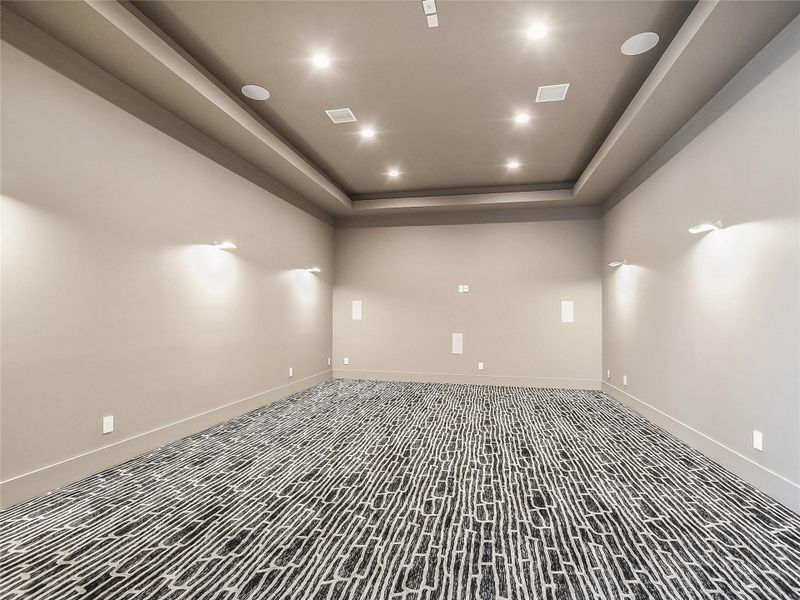 This room features recessed ceiling lights and a tray ceiling