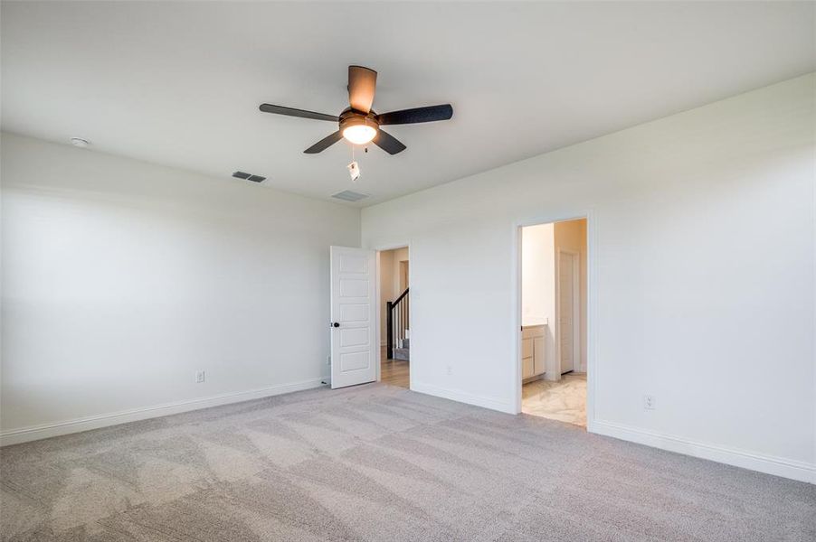 Unfurnished bedroom with light carpet, ensuite bathroom, and ceiling fan Unfurnished bedroom with light carpet, ensuite bathroom, and ceiling fan