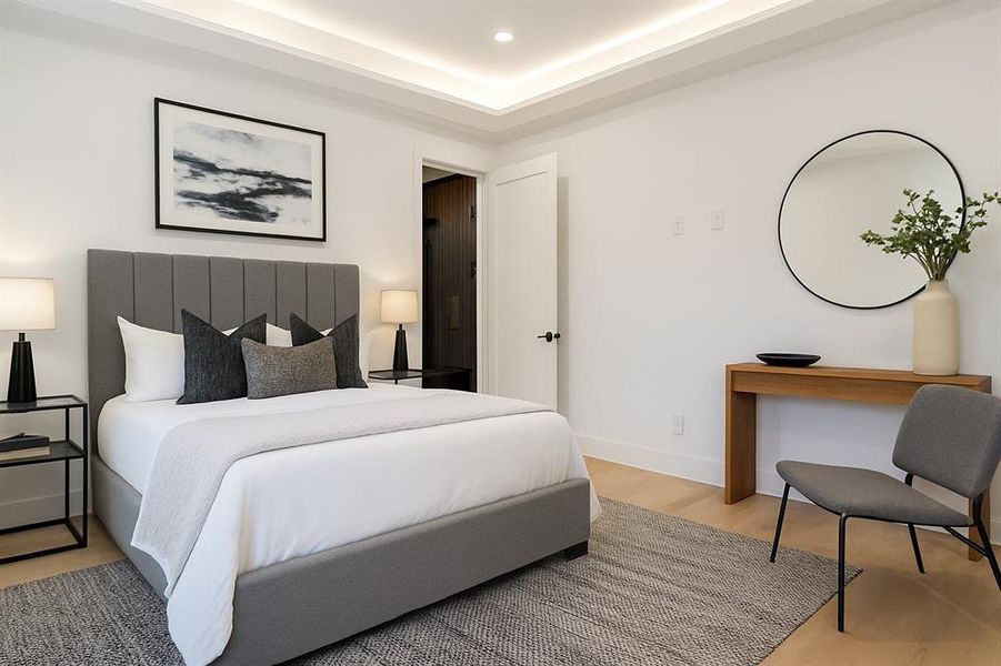 Secondary suite Bedroom featuring light wood finished floors, a tray ceiling, and recessed lighting
