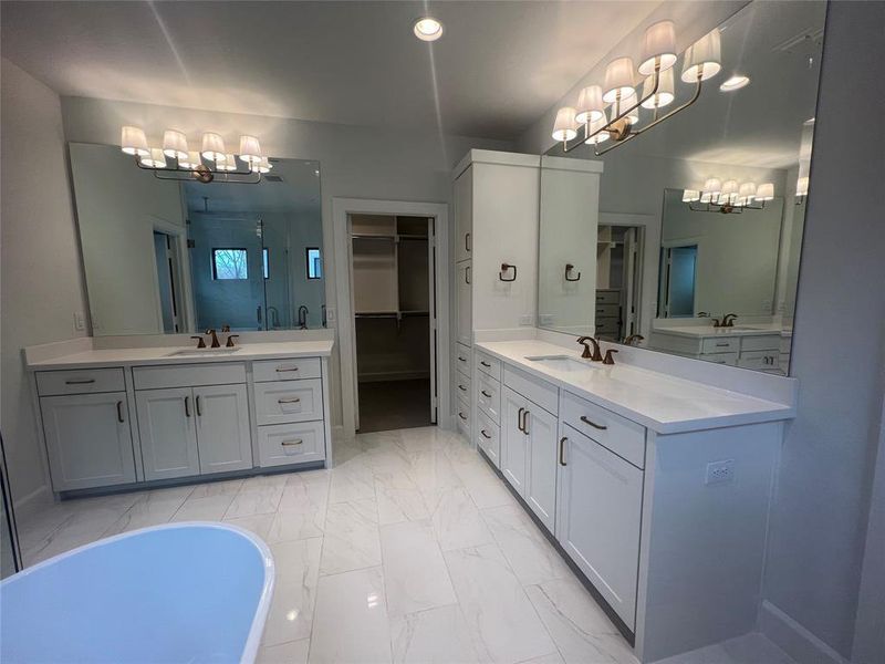 Bathroom featuring a notable chandelier, a bath to relax in, tile floors, and dual bowl vanity