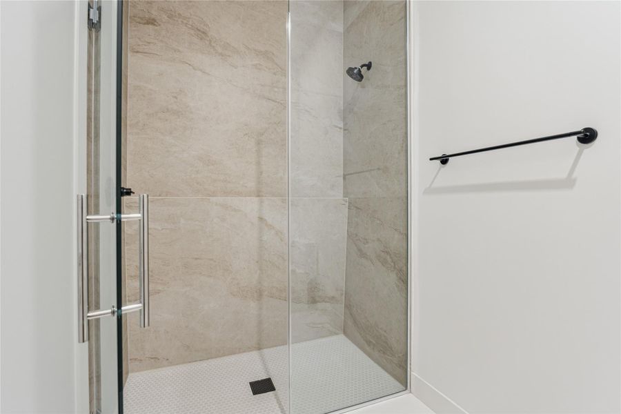 The Jack and Jill bathroom features porcelain slab shower walls and flooring for a sleek, modern look. The Jack and Jill bathroom features porcelain slab shower walls and flooring for a sleek, modern look.