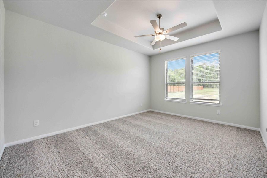 Enjoy your elegant primary bedroom featuring vaulted ceilings and large windows.