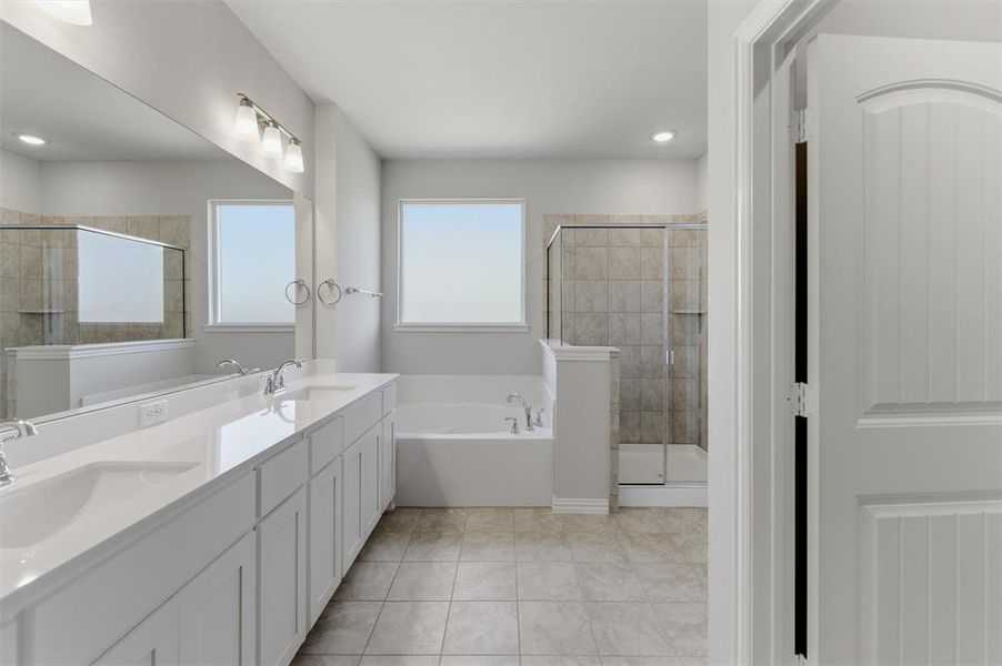 Full bath with double vanity, a stall shower, a garden tub, and light tile patterned flooring