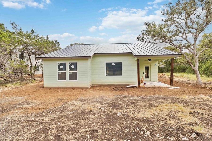 Back of home with covered patio w/ ceiling fan