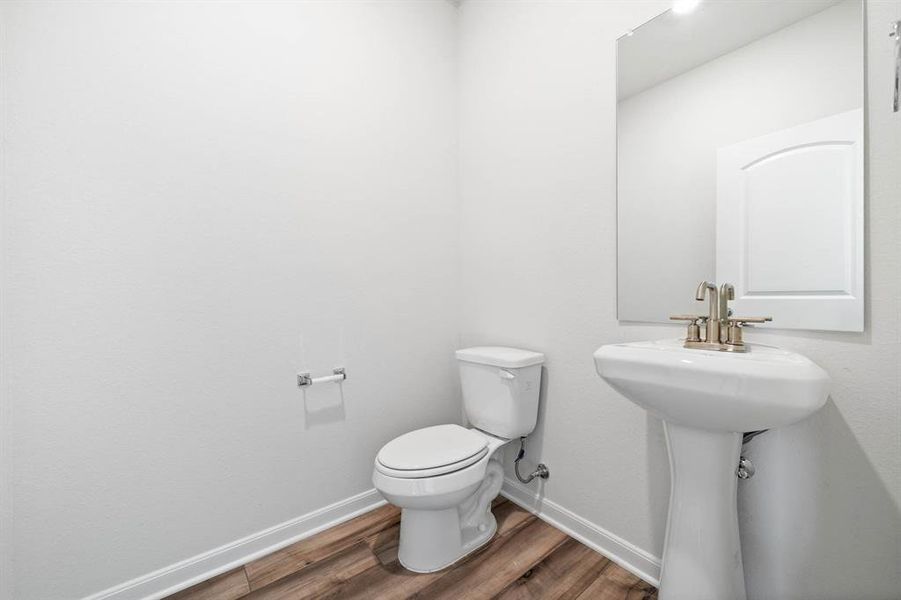 Bathroom with hardwood / wood-style flooring and toilet