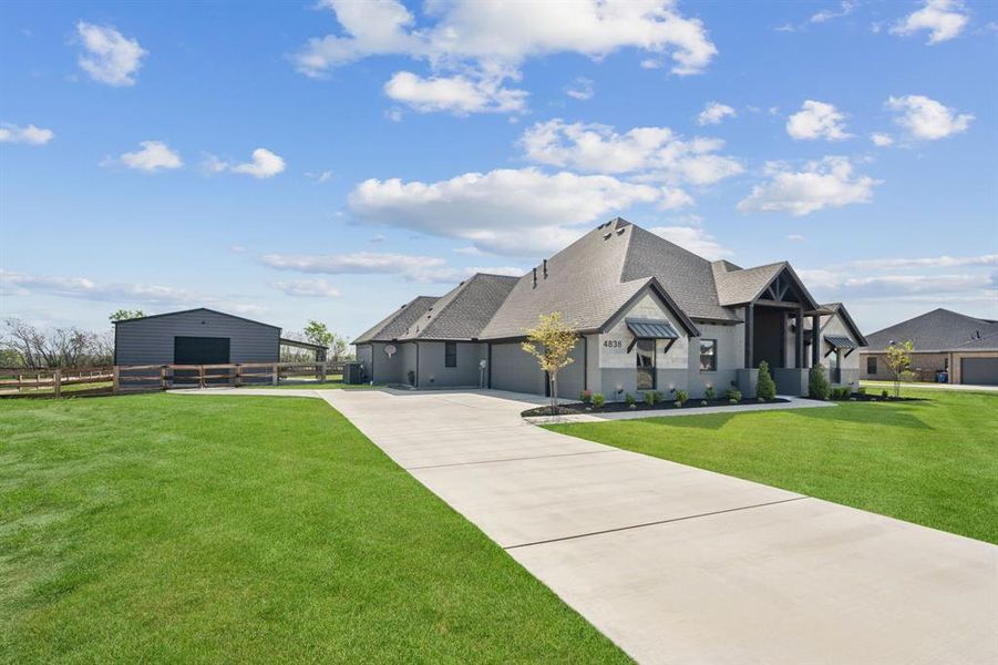 View of front of property with an outbuilding and concrete driveway