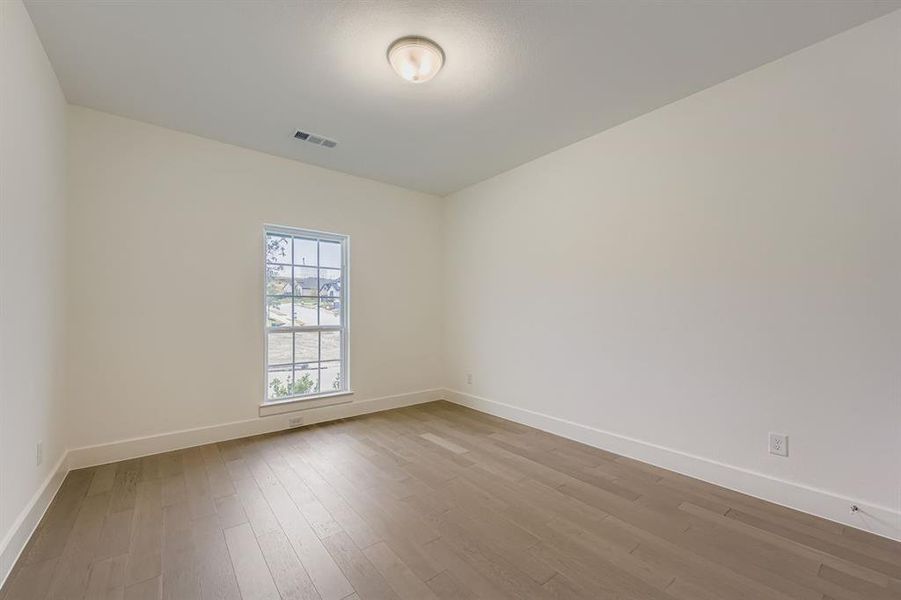 Bedroom featuring baseboards and light wood-type flooring Bedroom featuring baseboards and light wood-type flooring