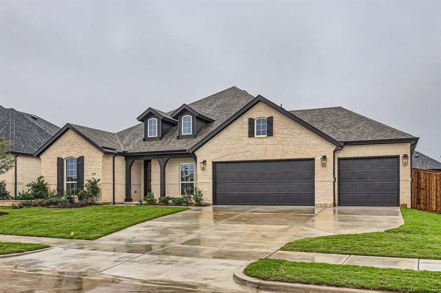 French country style house featuring a garage and a front yard