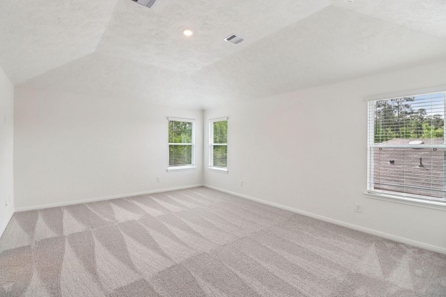 Relax and recharge in this stunning primary suite! This expansive room offers plush carpeting, neutral custom paint, high sloped ceilings, recessed lighting and large windows fitted with privacy blinds—perfect for unwinding after a long day.