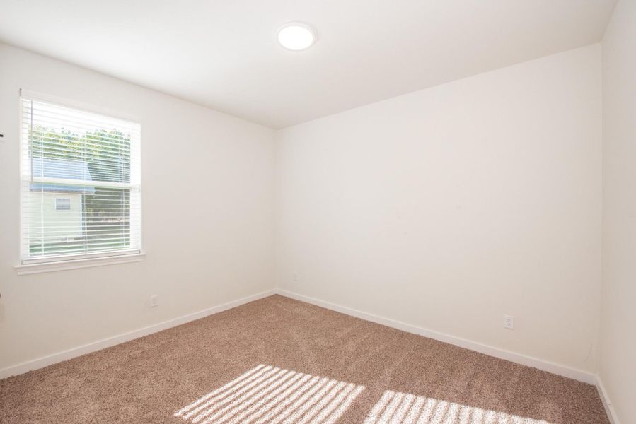 Spare room featuring carpet and baseboards