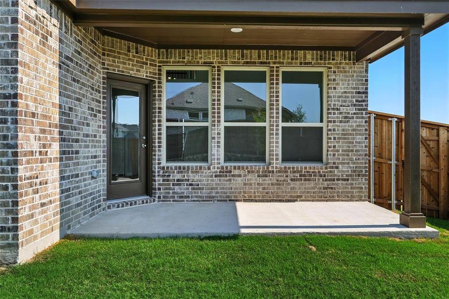 Doorway to property featuring brick siding and a patio area Doorway to property featuring brick siding and a patio area