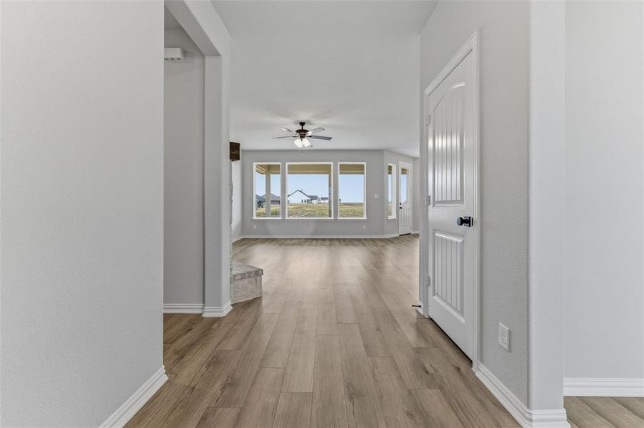 Corridor with light wood-style flooring and baseboards