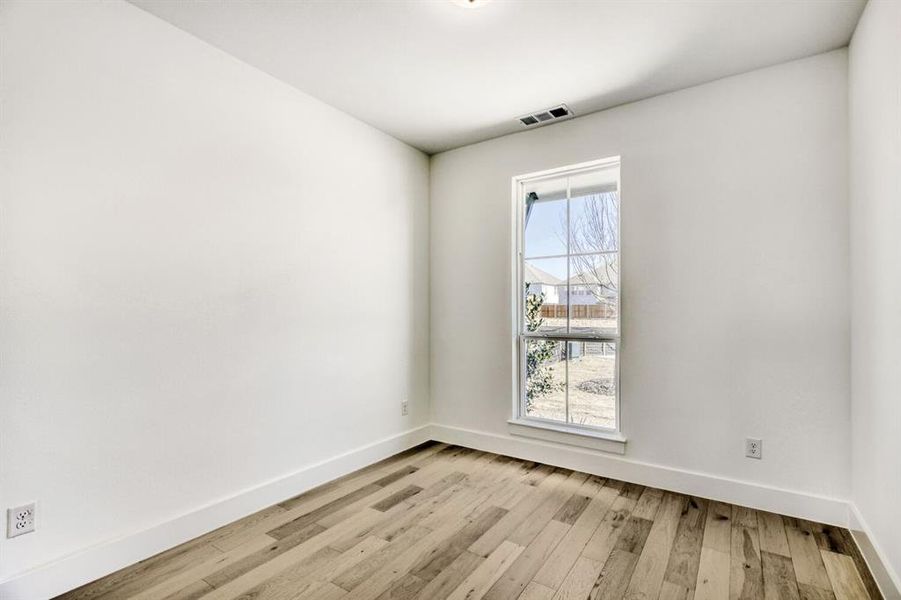 Unfurnished room with light wood-style floors and baseboards