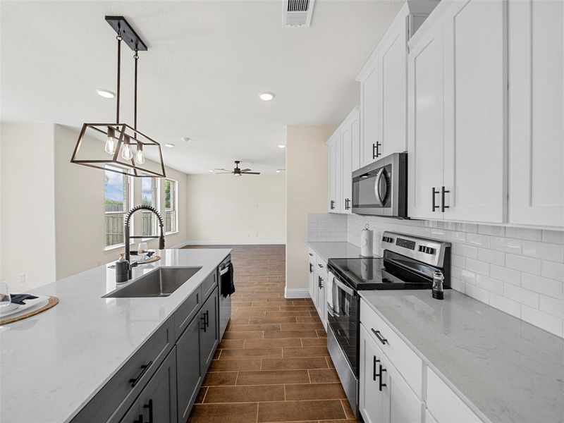 Kitchen with sink, appliances with stainless steel finishes, and white cabinetry