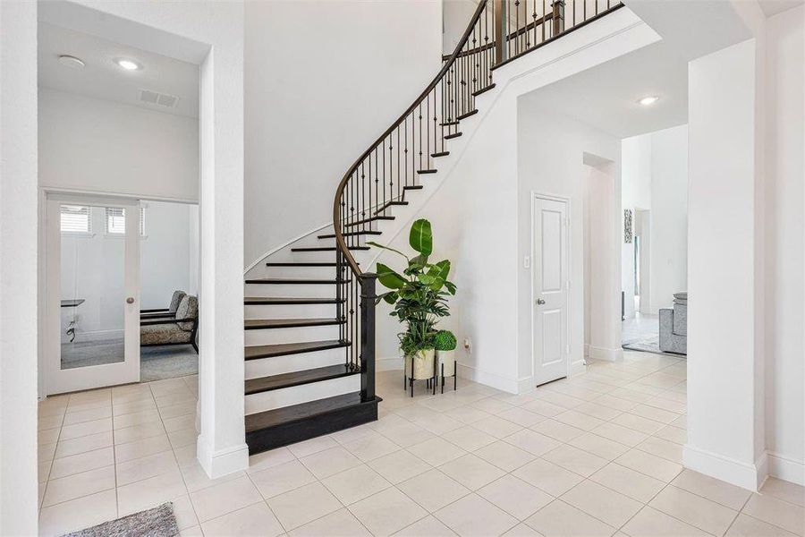 Step into your grand entrance and foyer, where solid wood stairs and an elegant iron banister create a stunning first impression. The hallway flows seamlessly into a secluded study and a convenient half bath.