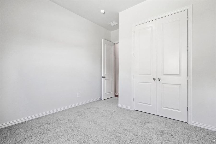 Unfurnished bedroom featuring a closet and light carpet